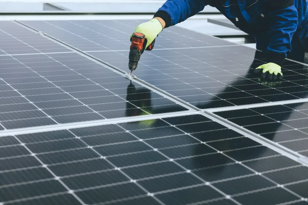 installing-solar-panels A person installs solar panels