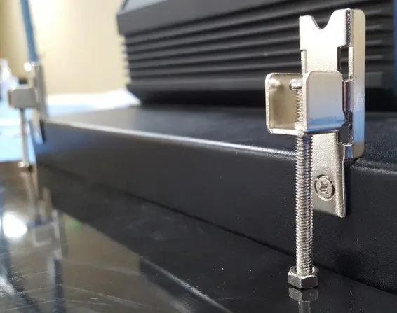 Close-up of a panel mounting clamp tightened against the rear of a panel to secure a PC2300B Series industrial panel PC.