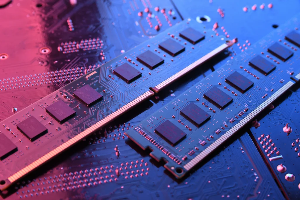 Two sticks of RAM sitting on a circuit board with dramatic lighting.
